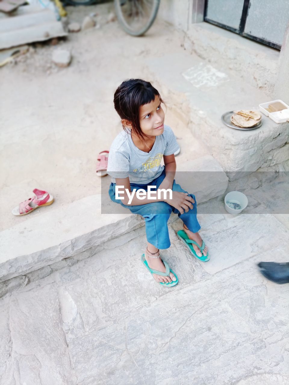 High angle view of cute girl sitting outdoors