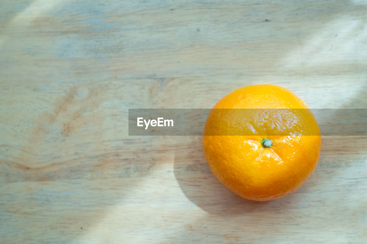 CLOSE-UP OF ORANGE ON TABLE