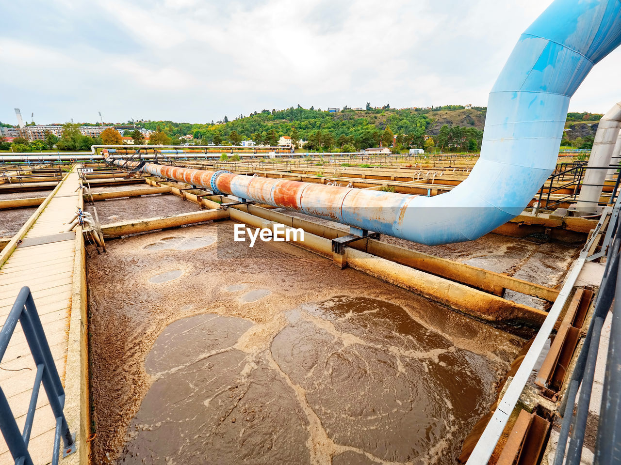 Pipe and walk bridge above waste water pool. sedimentation tank in a sewage treatment plant