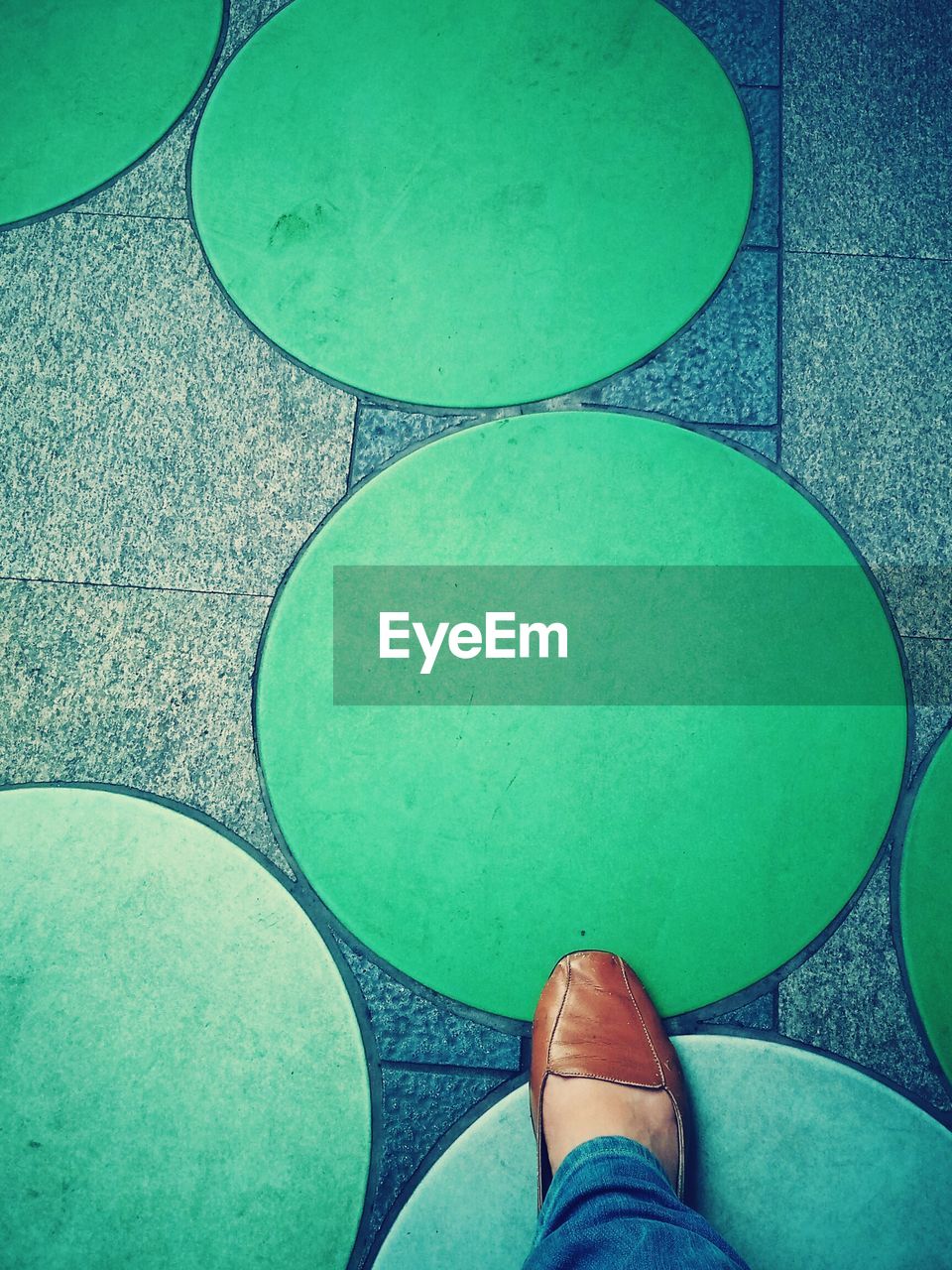 LOW SECTION OF WOMAN STANDING ON GREEN SWIMMING POOL