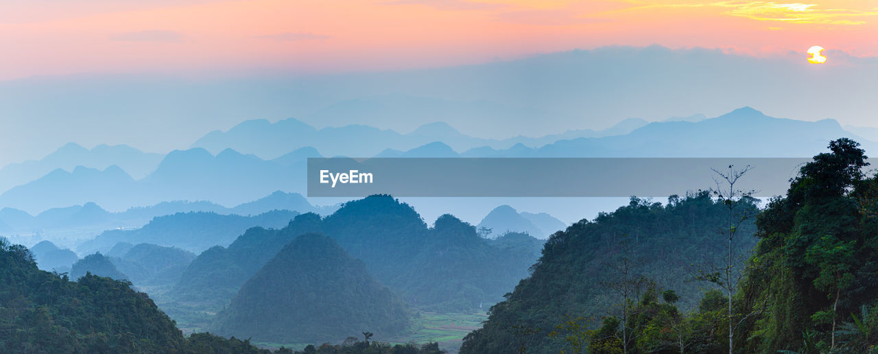 PANORAMIC SHOT OF MOUNTAINS AGAINST SKY DURING SUNSET