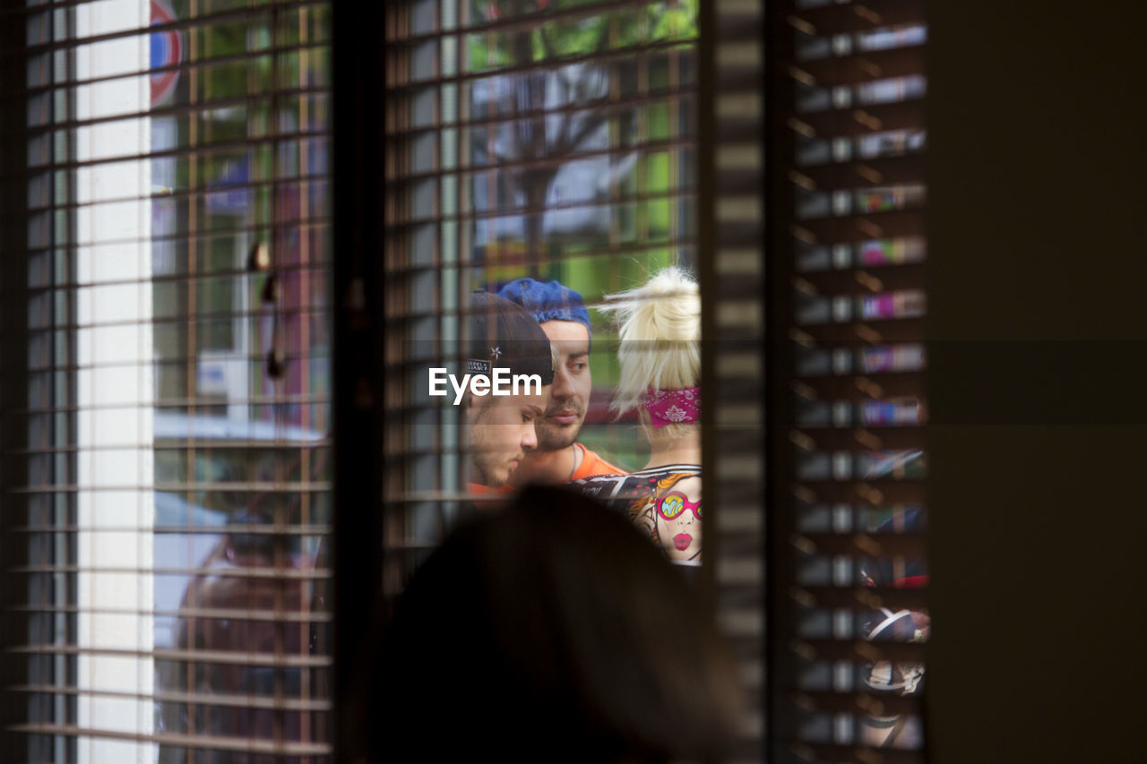 PORTRAIT OF WOMAN LOOKING THROUGH WINDOW