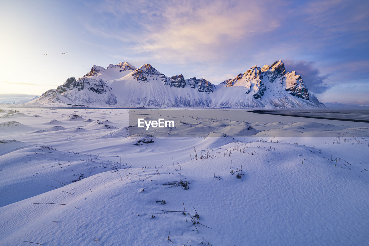 Scenic view of snowcapped mountain against sky during sunset