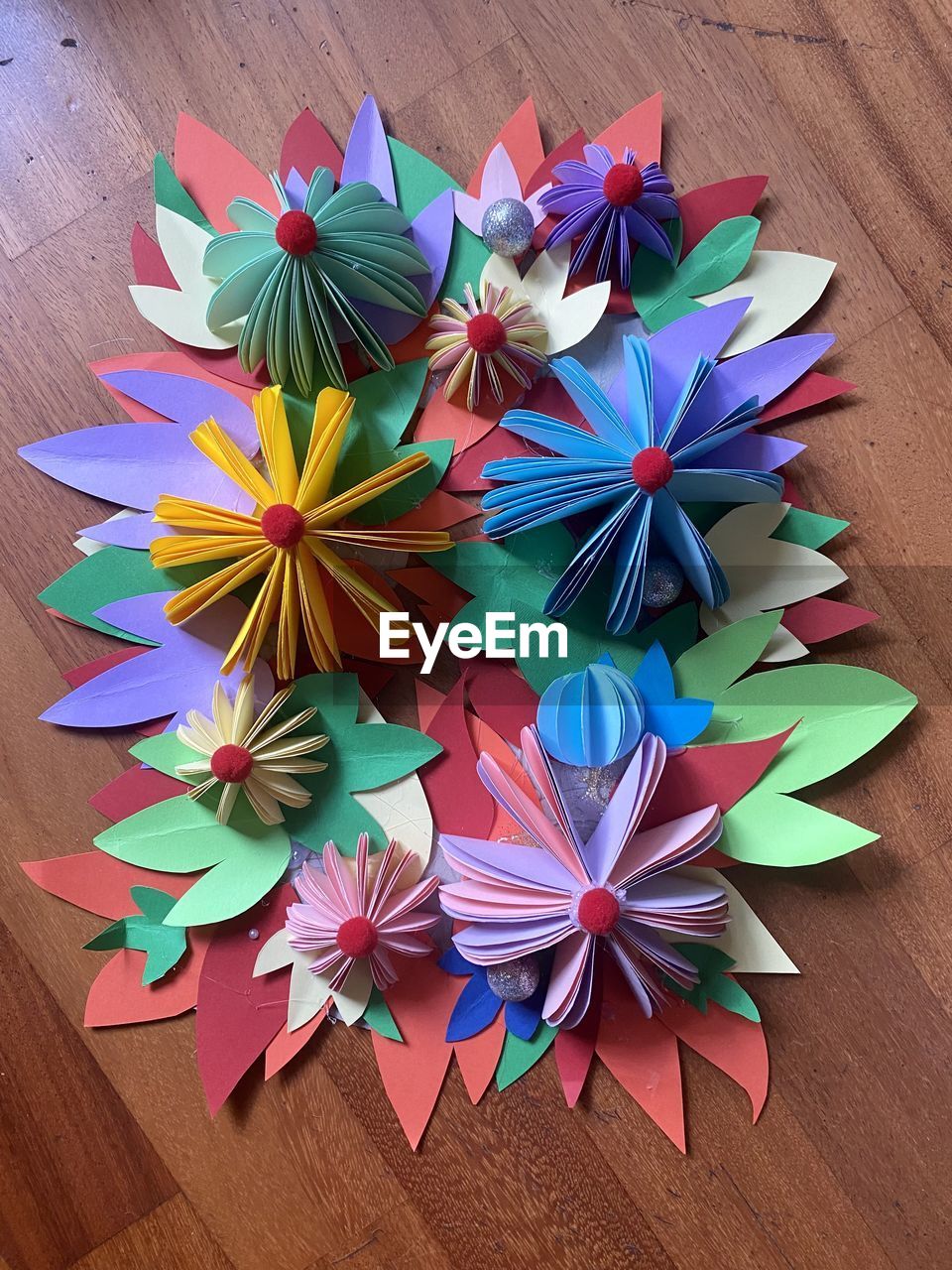 wheel, multi colored, origami paper, origami, art paper, high angle view, art, creativity, no people, paper, flower, wood, indoors, craft, table, petal, large group of objects, still life, variation, close-up, directly above, decoration, shape, pinwheel toy, blue
