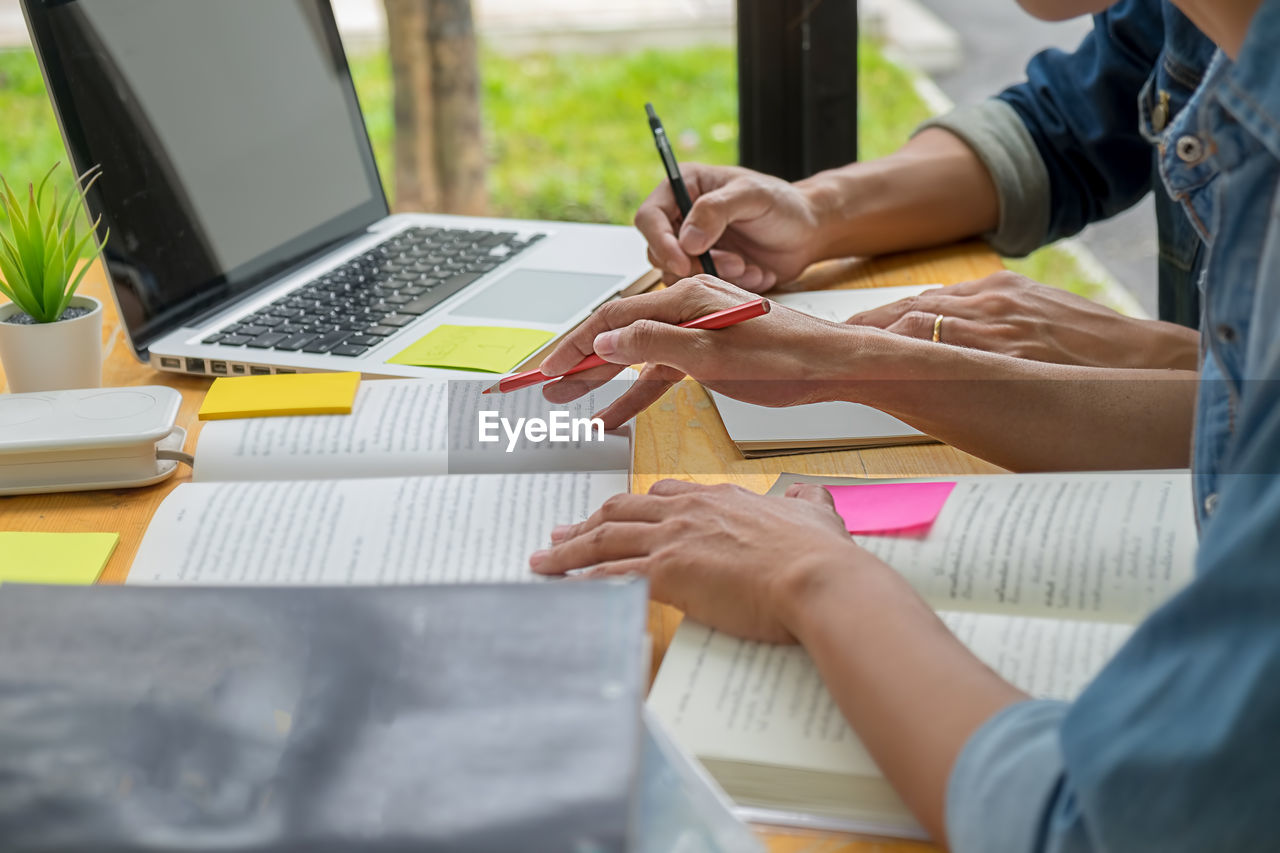 MIDSECTION OF WOMAN WORKING WITH LAPTOP