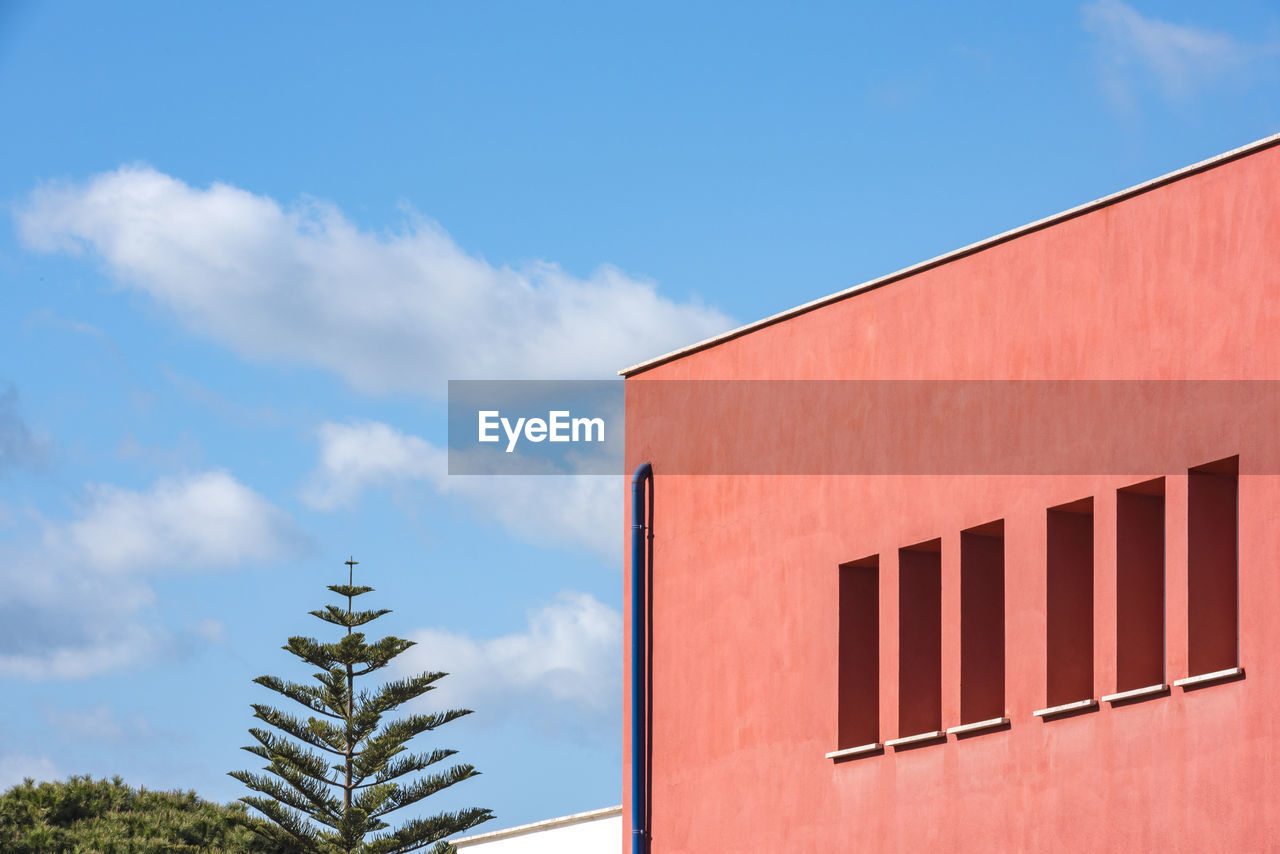 LOW ANGLE VIEW OF BUILDINGS AGAINST BLUE SKY