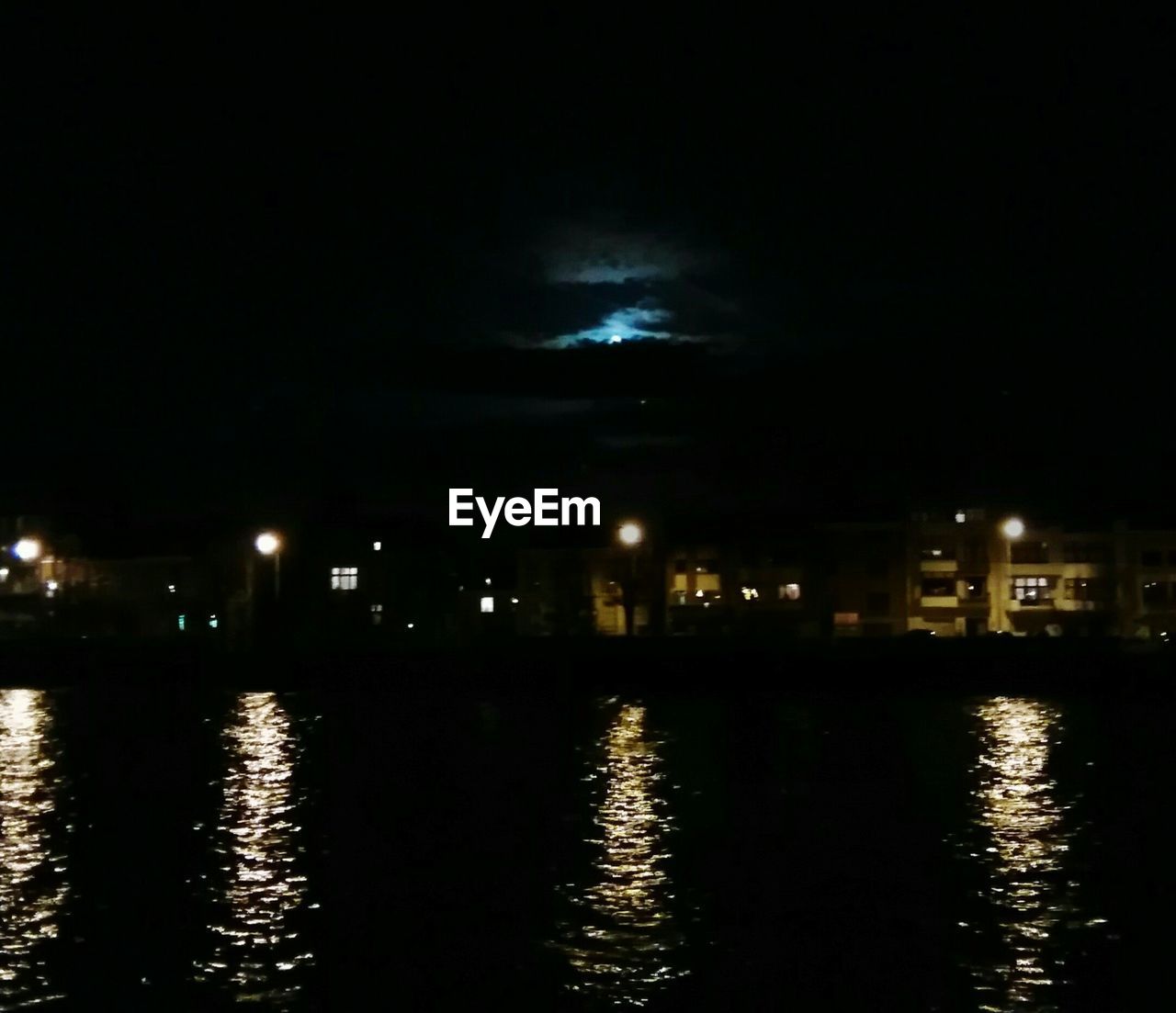 REFLECTION OF ILLUMINATED WATER IN SKY AT NIGHT