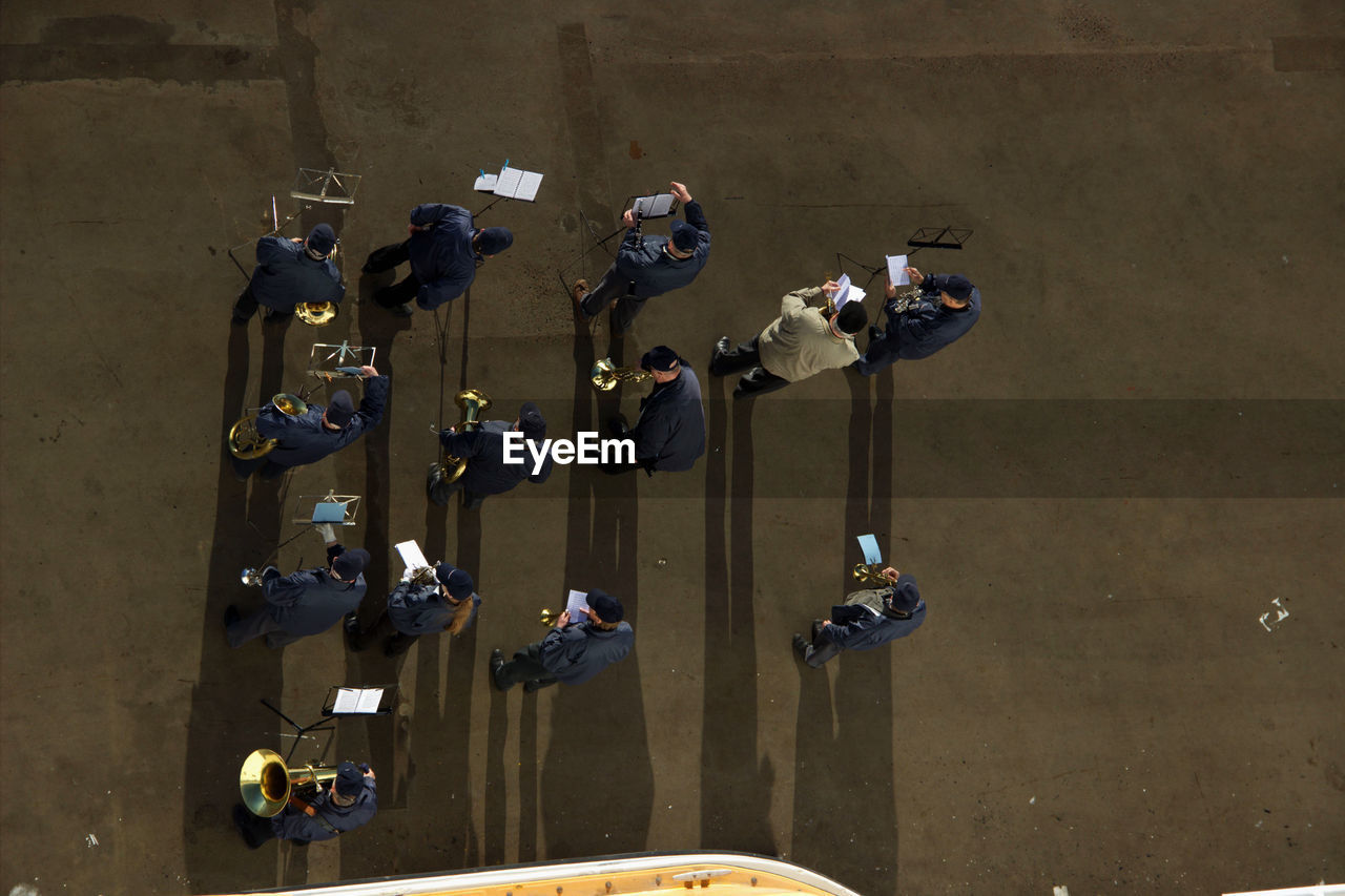 High angle view of men practicing music on footpath