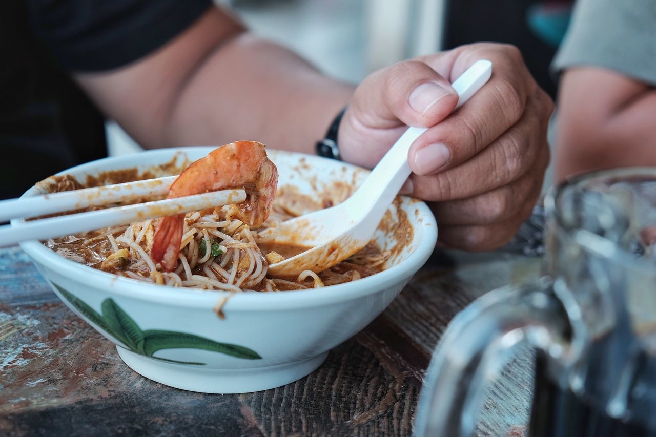 Midsection of person having food in bowl