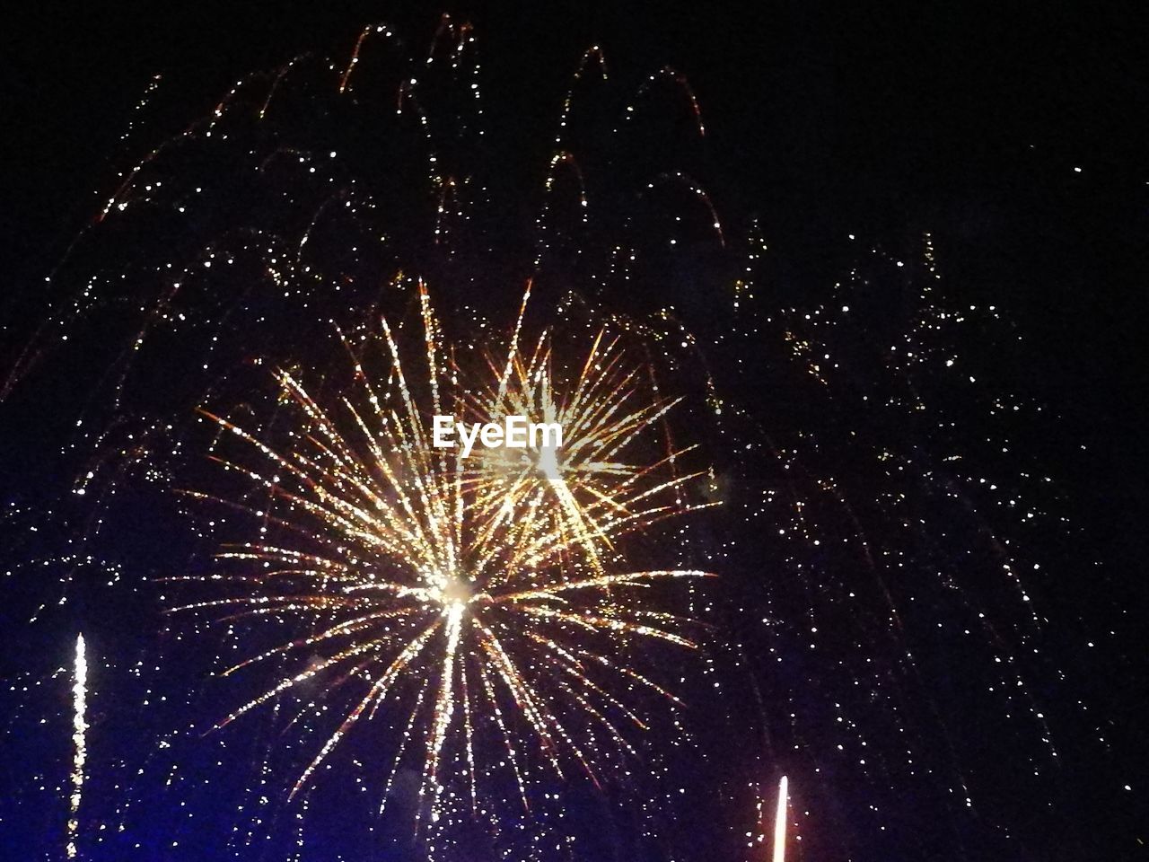 LOW ANGLE VIEW OF FIREWORKS IN SKY AT NIGHT