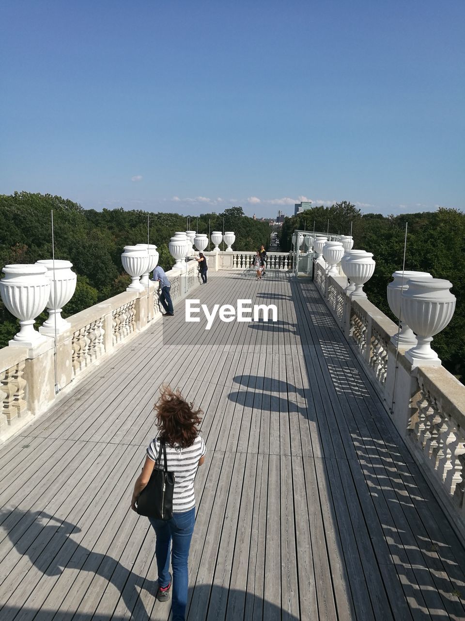 HIGH ANGLE VIEW OF WOMAN STANDING ON WALKWAY