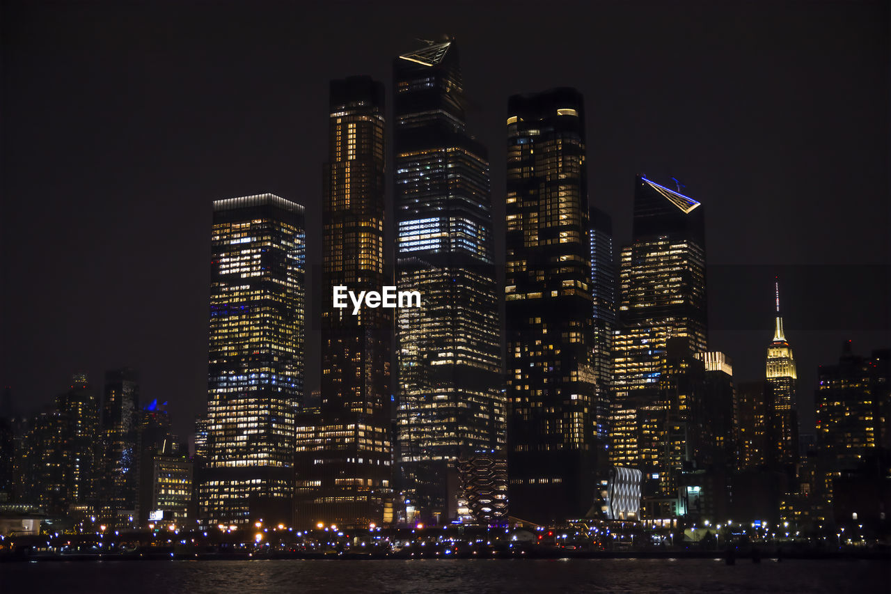 ILLUMINATED MODERN BUILDINGS AGAINST SKY AT NIGHT