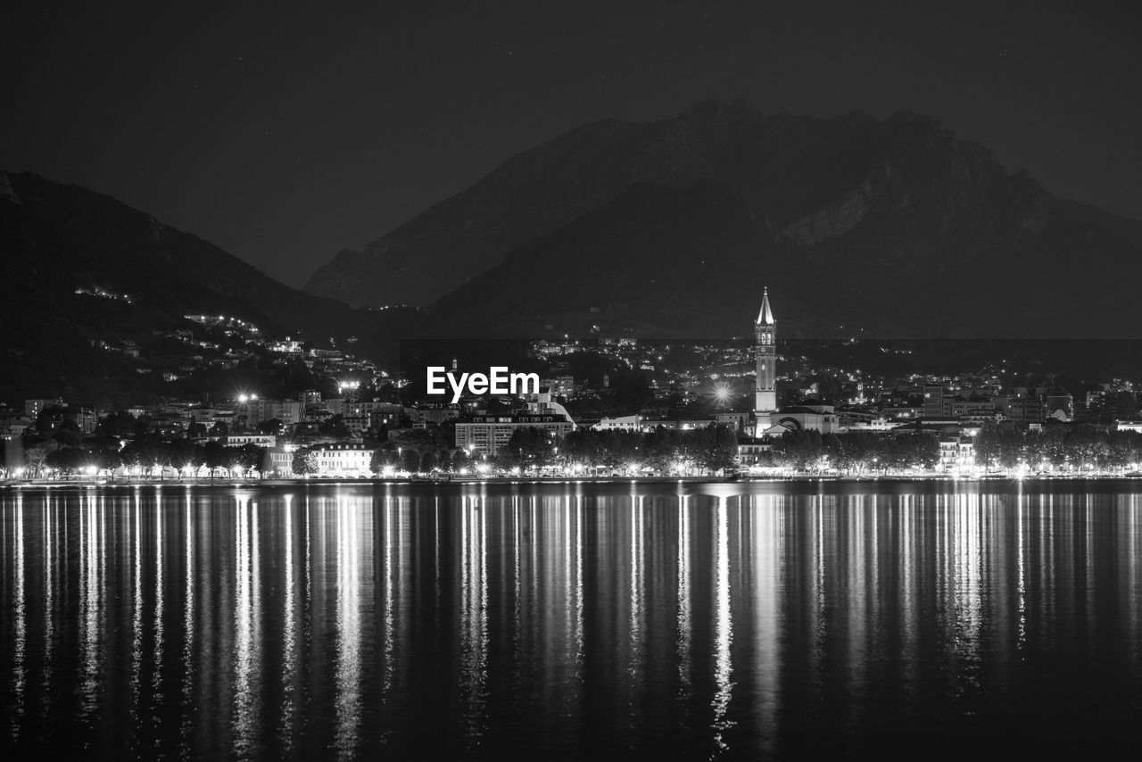 VIEW OF ILLUMINATED CITY AT WATERFRONT