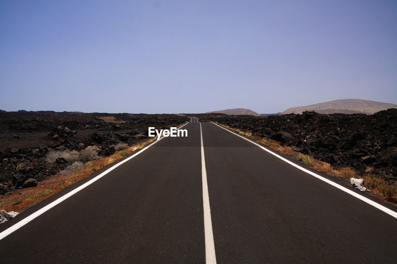 EMPTY ROAD ALONG LANDSCAPE AND AGAINST CLEAR SKY