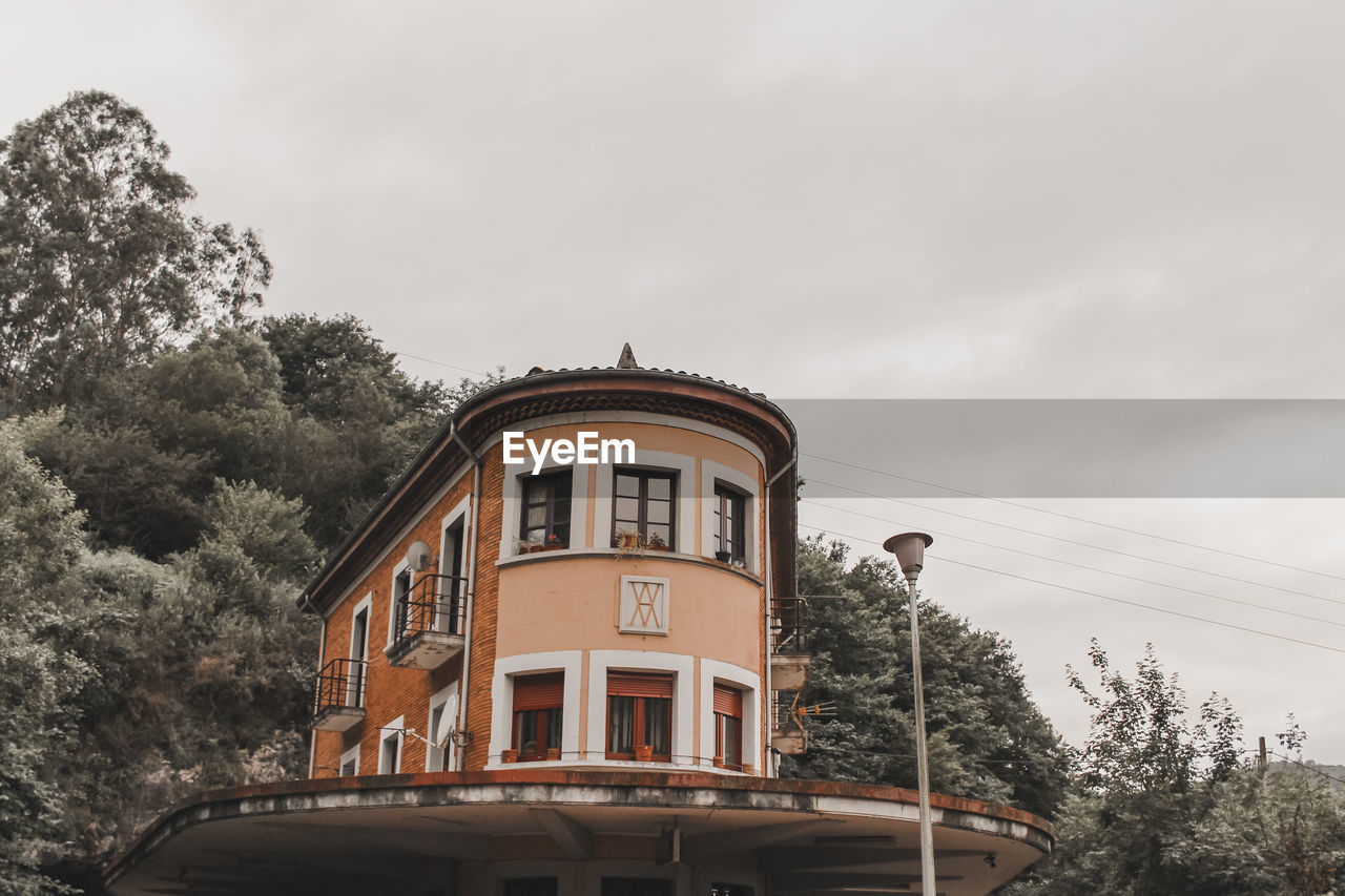 LOW ANGLE VIEW OF HOUSE AND BUILDING AGAINST SKY