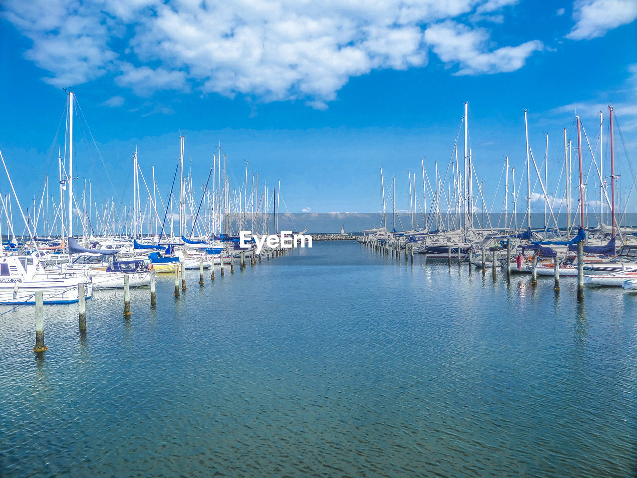 Boats moored at harbor against sky