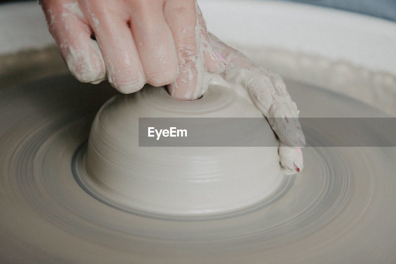 Midsection of woman at pottery workshop