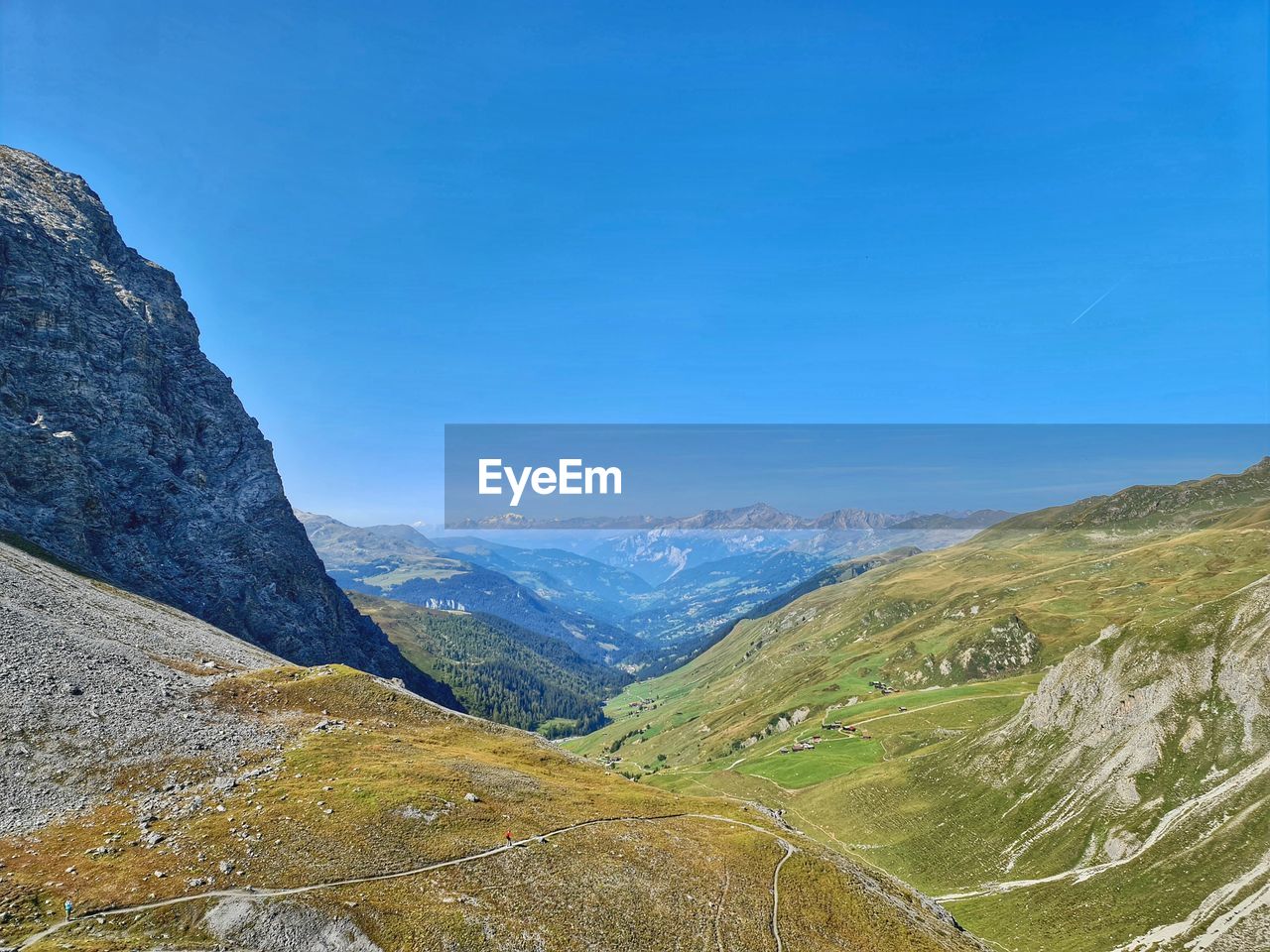 Scenic view of mountains against blue sky