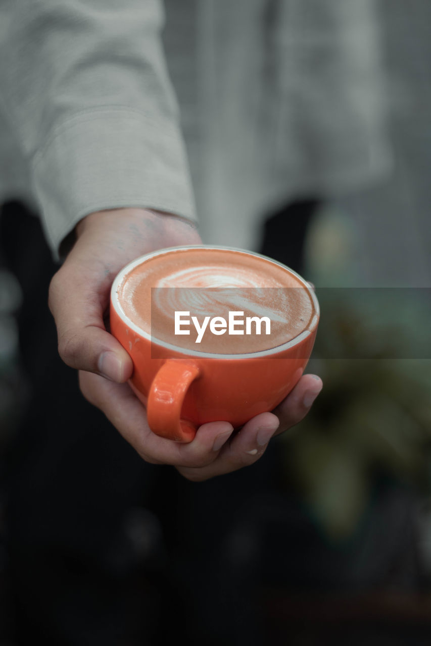 Close-up of hand holding coffee cup