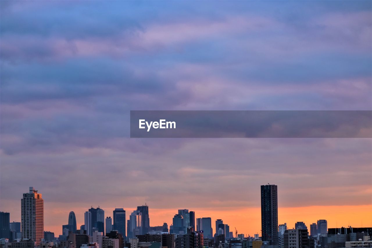 Modern buildings against sky during sunset