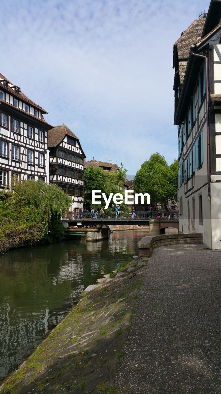 BUILDING BY RIVER AGAINST SKY