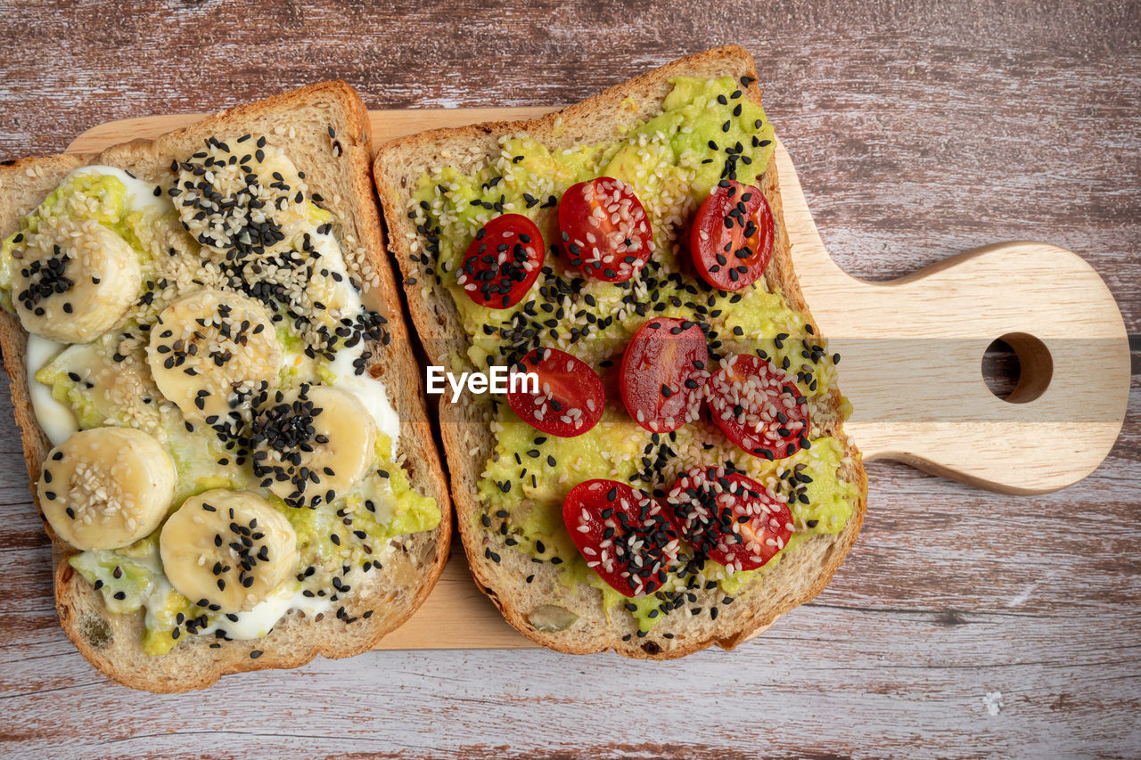 Healthy breakfast toasts with avocado toast, tomato, banana, yoghurt with whole grain sandwich