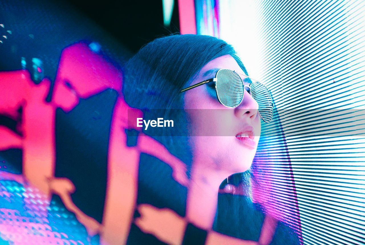 CLOSE-UP OF SMILING YOUNG WOMAN WITH EYEGLASSES