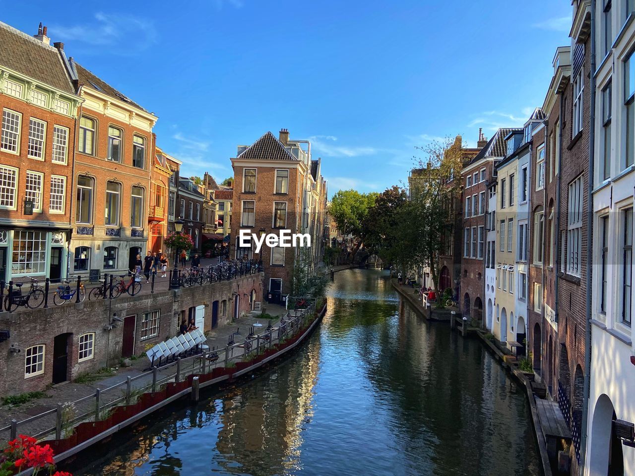 Canal amidst buildings in city against sky