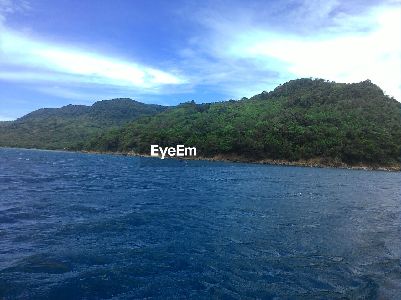 SCENIC VIEW OF SEA AND MOUNTAINS AGAINST BLUE SKY