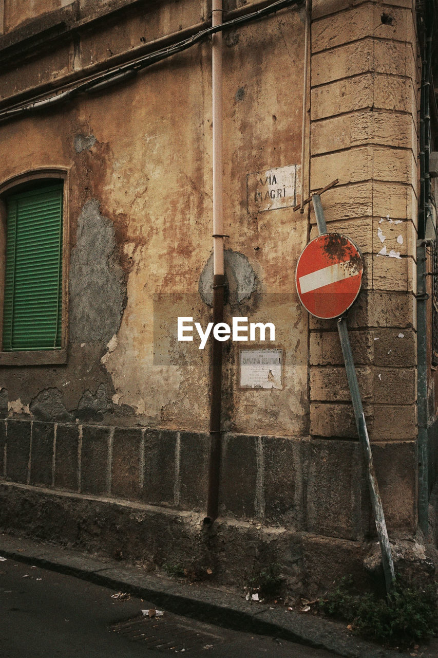 urban area, road, street, wall, architecture, built structure, building exterior, sign, infrastructure, road sign, no people, communication, alley, day, city, stop sign, wall - building feature, house, do not enter sign, building, outdoors, text, guidance, window, abandoned, red, warning sign