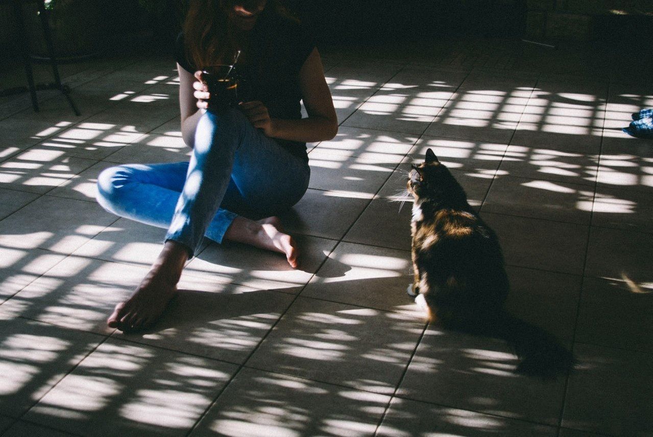 Woman sitting with a cat on floor