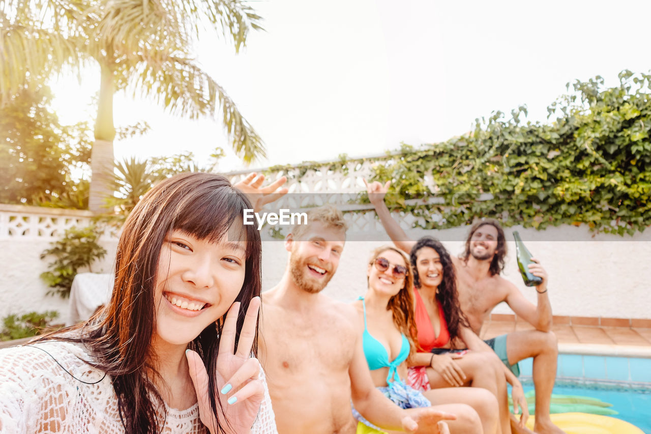 Portrait of smiling friends enjoying at swimming pool