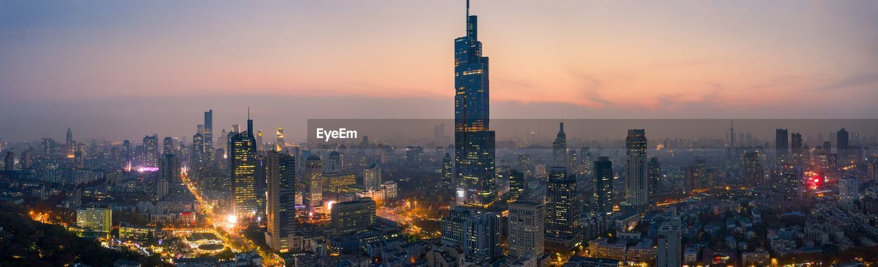 ILLUMINATED BUILDINGS AGAINST SKY DURING SUNSET