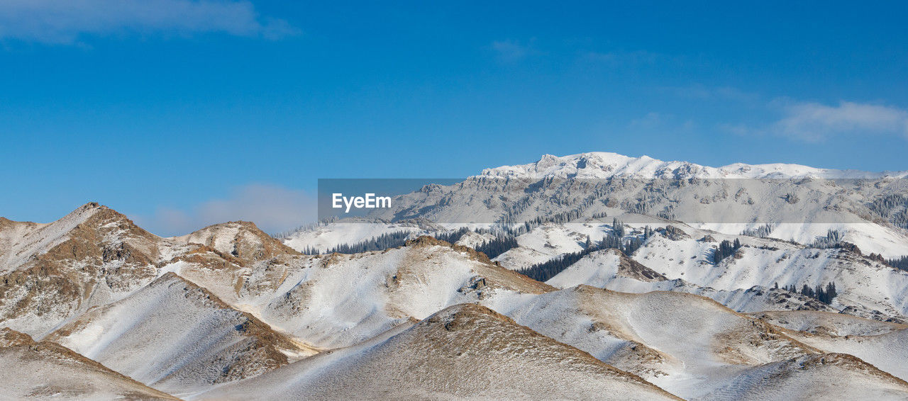 landscape, mountain, scenics - nature, environment, sky, mountain range, beauty in nature, nature, snow, winter, cold temperature, blue, plateau, cloud, travel destinations, no people, travel, land, tranquility, extreme terrain, ridge, snowcapped mountain, panoramic, tranquil scene, outdoors, non-urban scene, day, valley, tourism, geology, physical geography, rock, desert, mountain peak