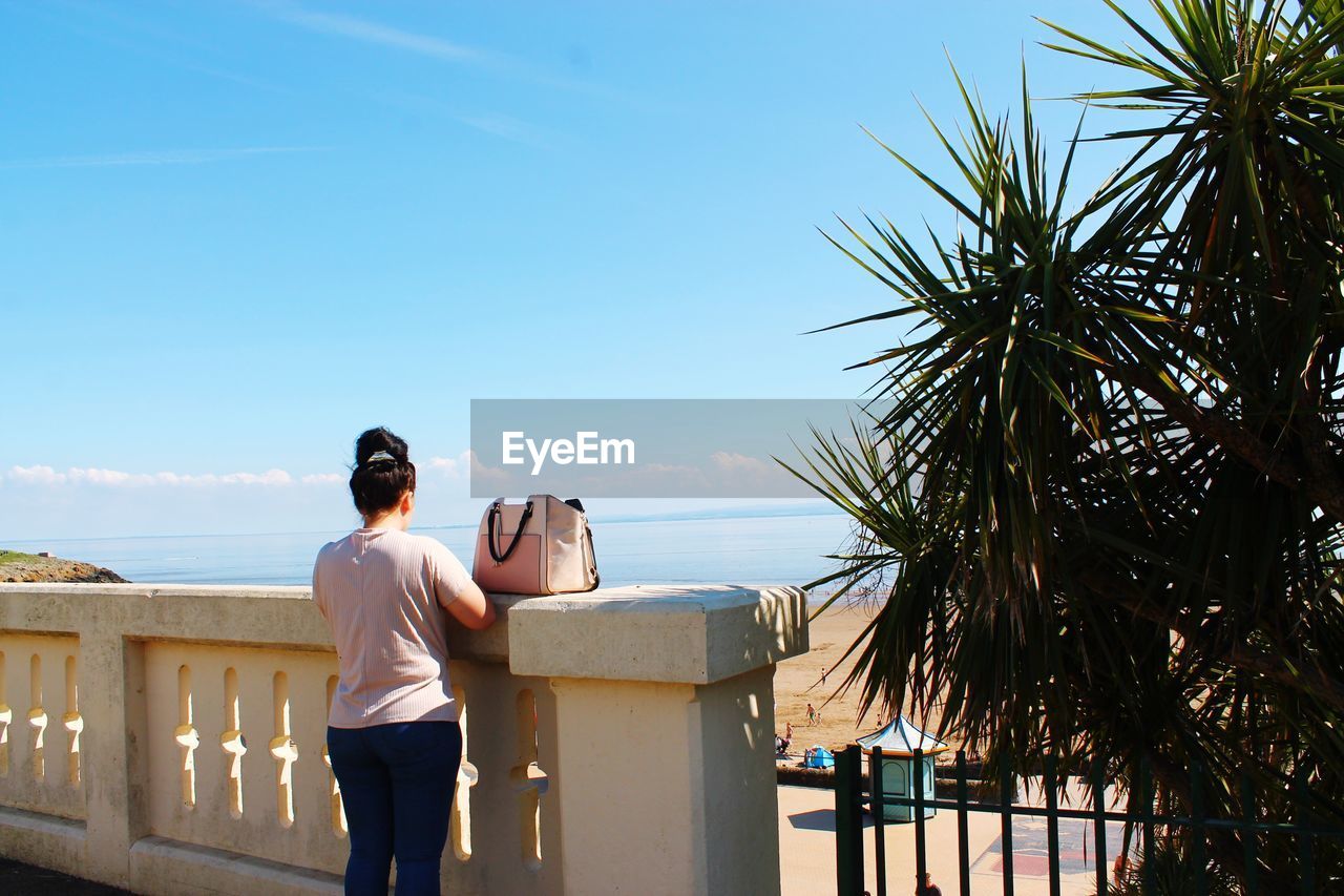 Rear view of woman looking at sea against sky