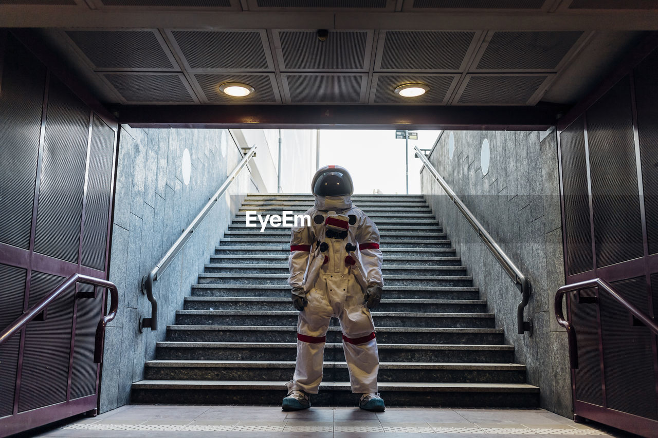 Male astronaut standing in front of staircase