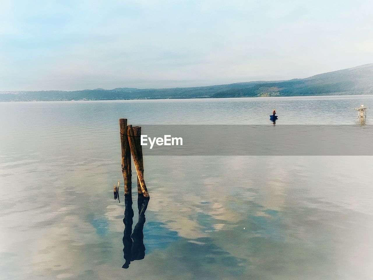 MEN FISHING IN SEA AGAINST SKY