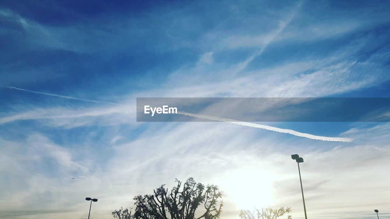 LOW ANGLE VIEW OF VAPOR TRAILS AGAINST SKY