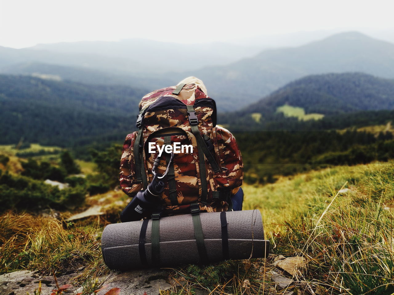 Rear view of backpacker sitting on mountain