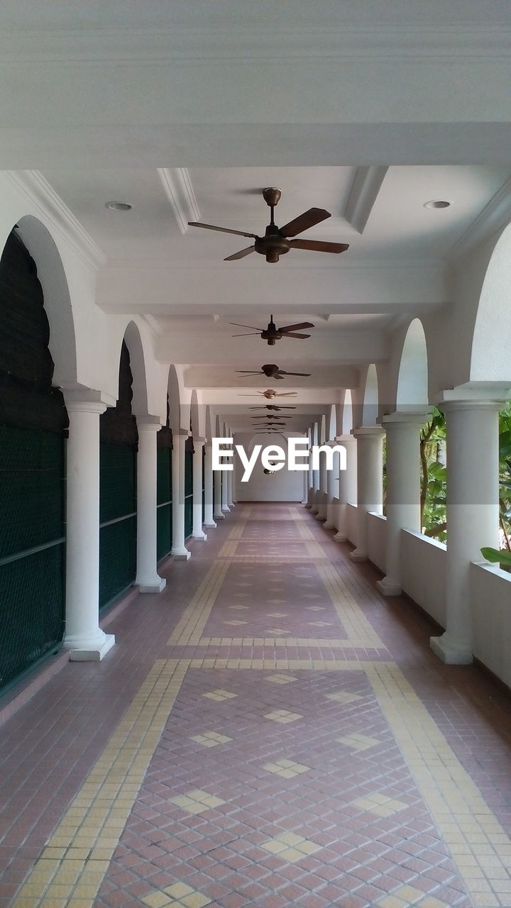 Ceiling fans hanging in empty corridor