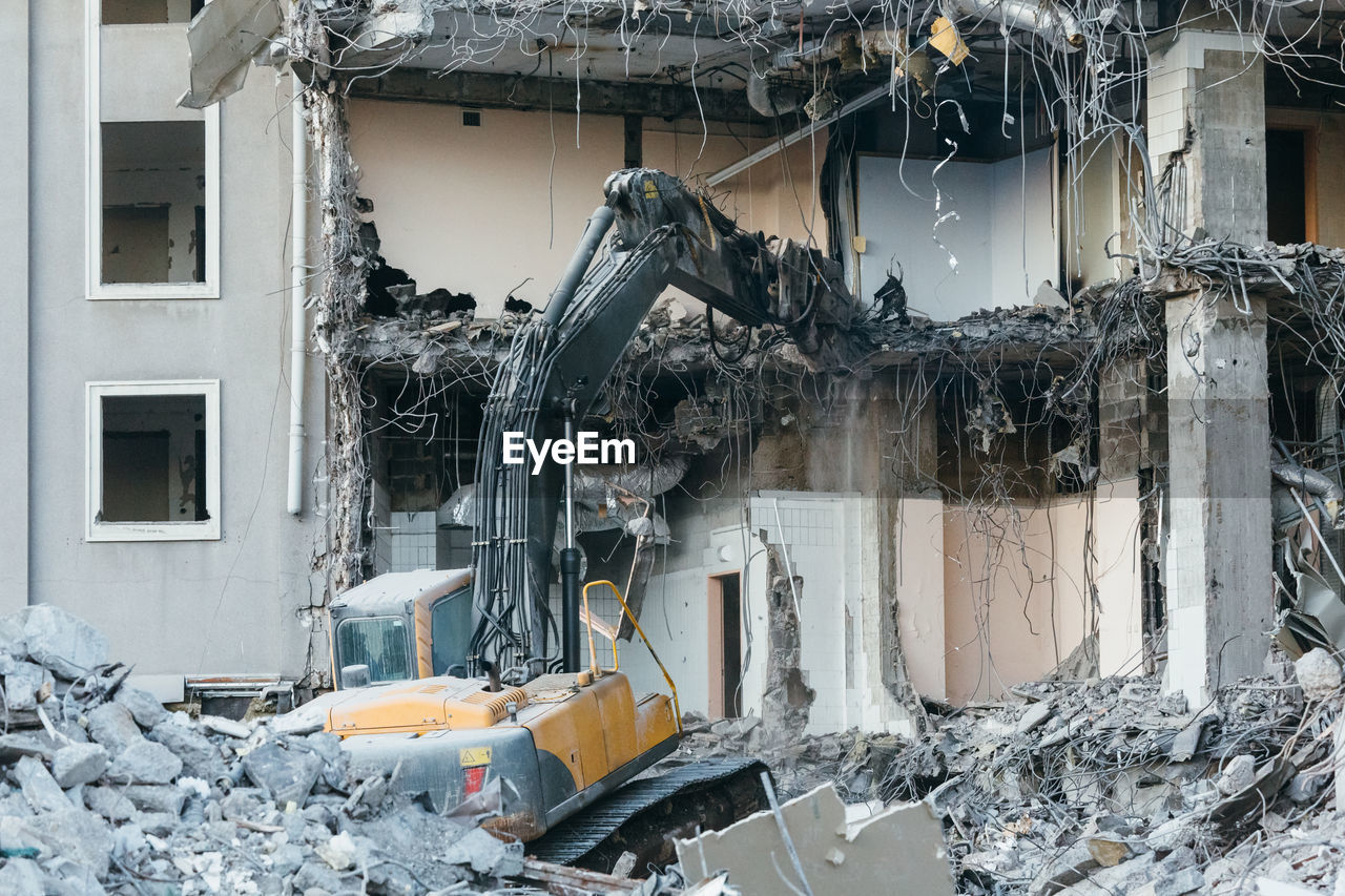 Photo of building demolition excavator, destruction of a building, house ruins, reconstruction