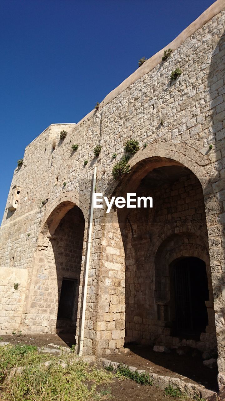 LOW ANGLE VIEW OF CASTLE AGAINST BLUE SKY