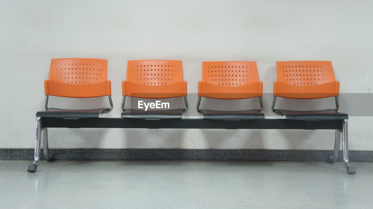 EMPTY CHAIRS AND TABLES AGAINST WALL