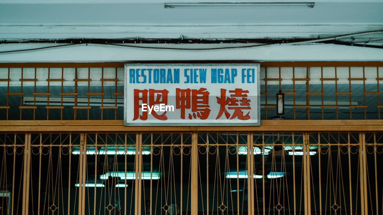 LOW ANGLE VIEW OF INFORMATION SIGN AGAINST BUILDING