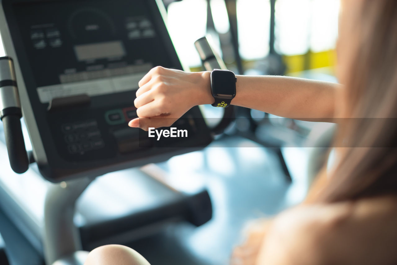 Close-up of woman wearing smart watch in gym