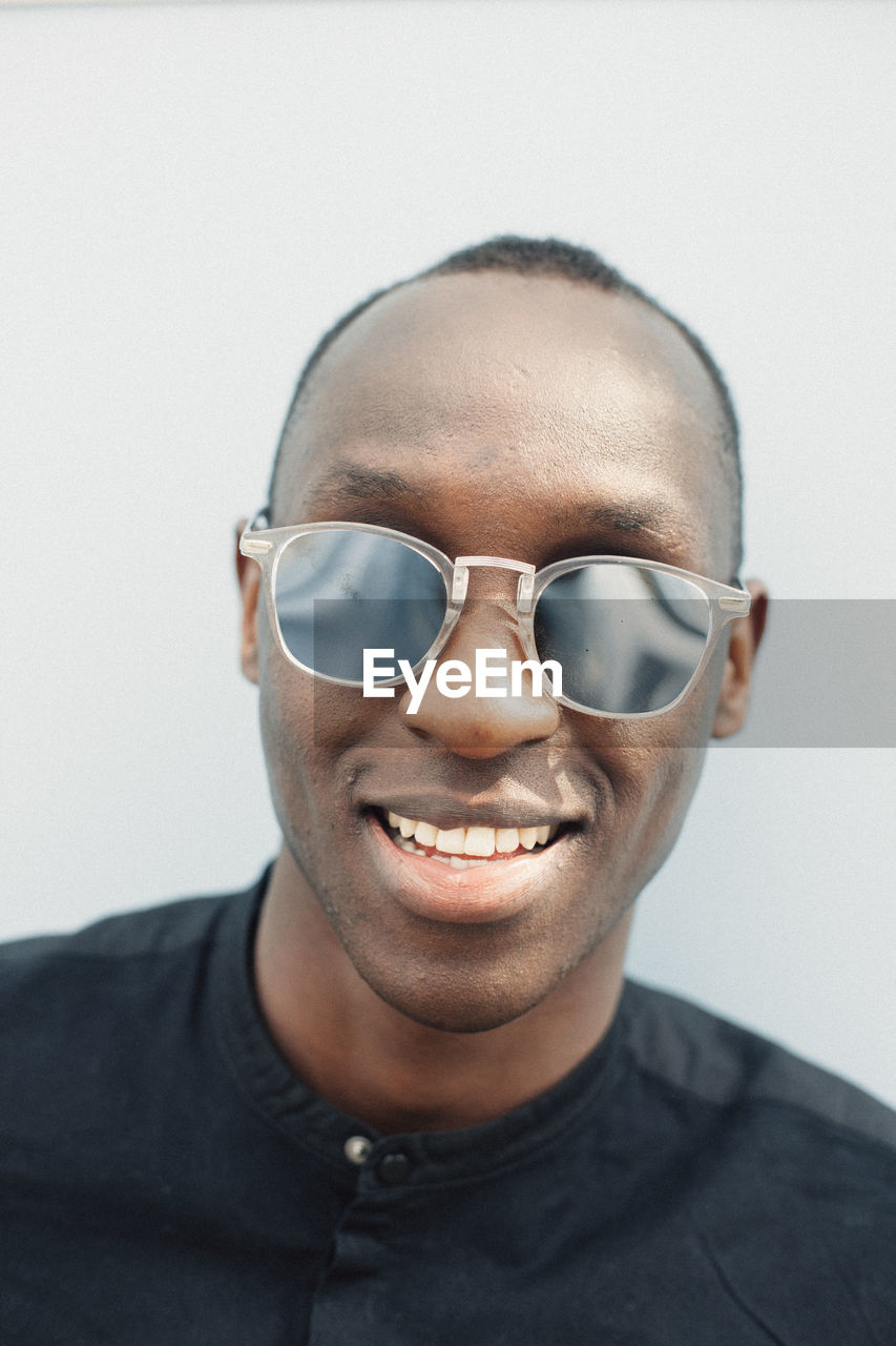 Portrait of serene young man with mirrored sunglasses