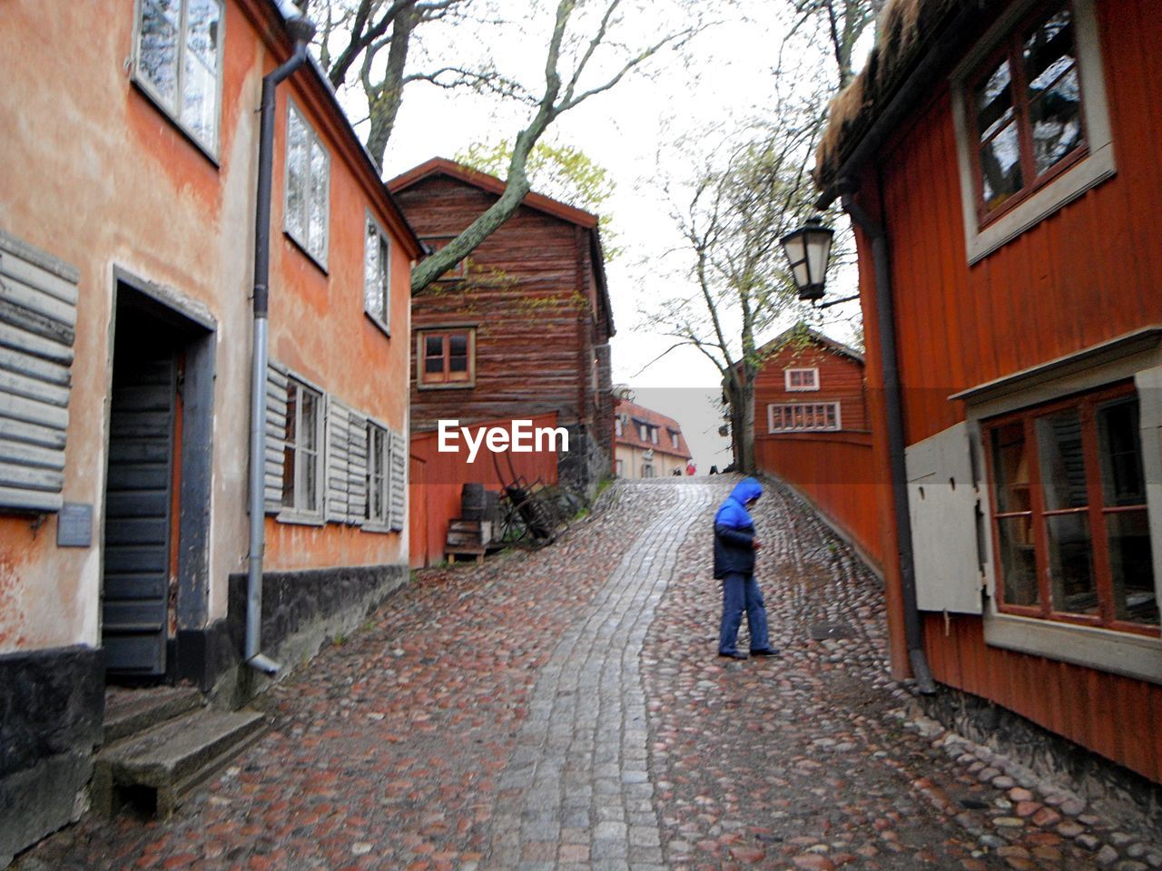 REAR VIEW OF A MAN WALKING ON STREET