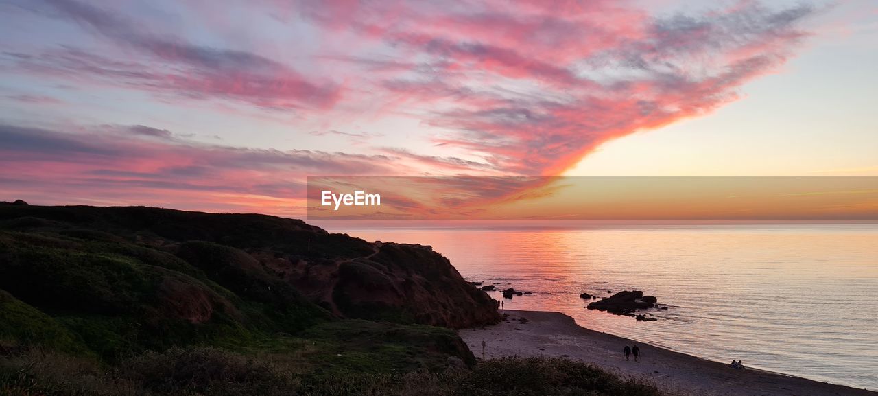 Scenic view of sea against dramatic sky during sunset