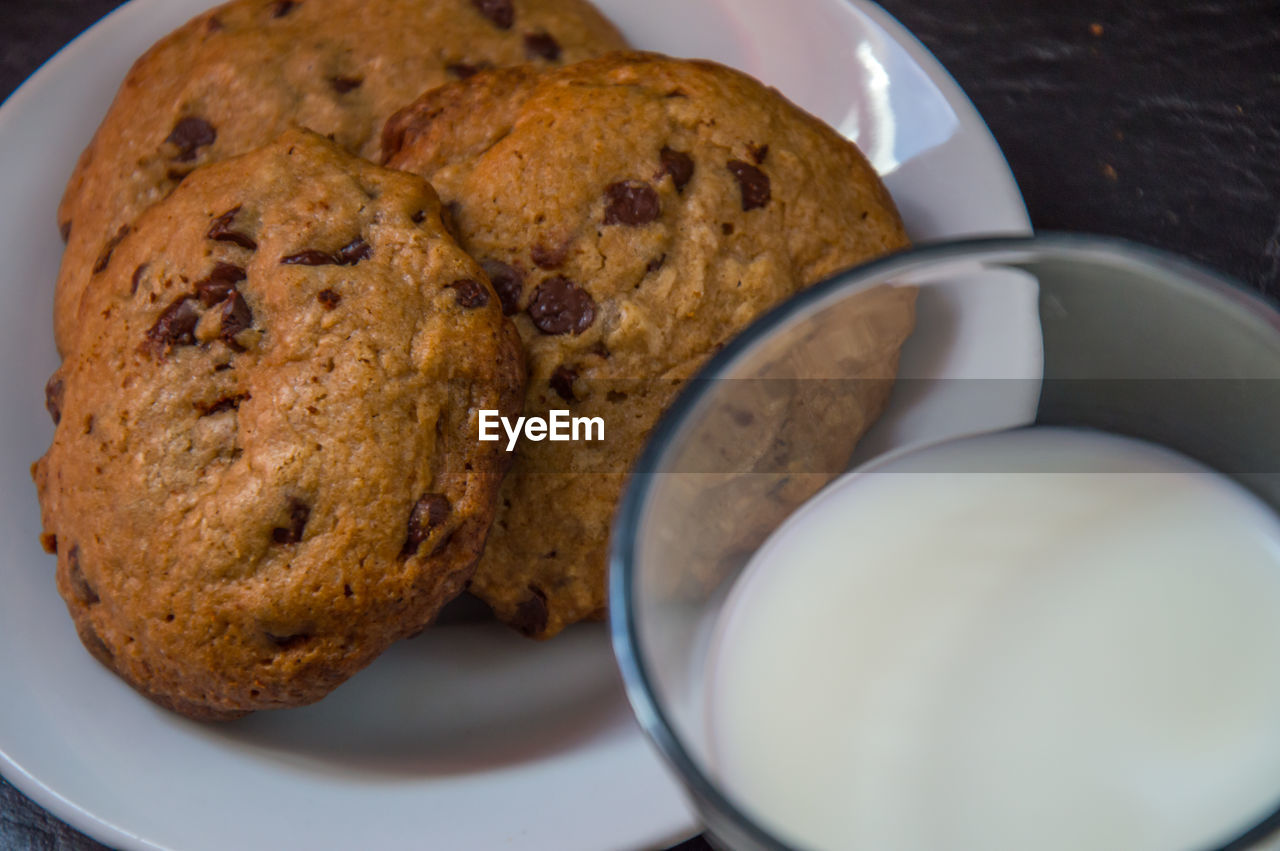 Close-up of milk cup by cookies on table