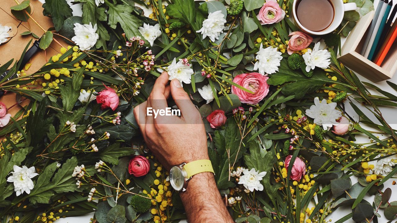 Cropped hand of man touching flowers